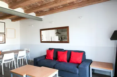 a living room with a blue couch and red pillows at My Address in Barcelona Old Town in Barcelona