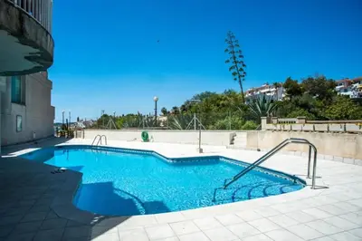 a large swimming pool with blue water at Comfortable House in Sitges with Shared Pool in Sitges