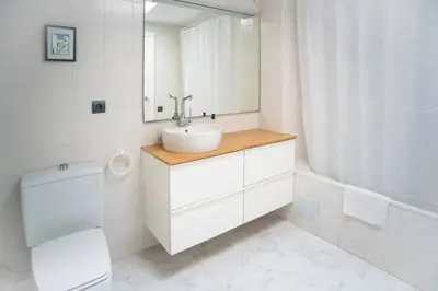 a white bathroom with a sink and a mirror at Comfortable House in Sitges with Shared Pool in Sitges