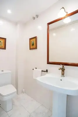 a white bathroom with a sink and a mirror at Comfortable House in Sitges with Shared Pool in Sitges