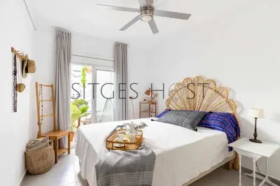 a bedroom with a large bed and a ceiling fan at Con patio y a 5 minutos de la playa in Sitges