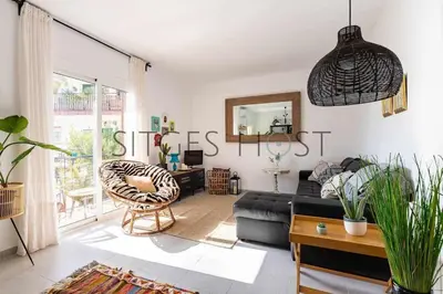 a living room with a couch and a chair at Con patio y a 5 minutos de la playa in Sitges