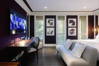a bedroom with a bed and a couch and a tv at Seventy Barcelona in Barcelona