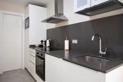 a black and white kitchen with a sink at White Sea by Seasidehomes in Castelldefels