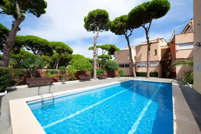 a swimming pool with trees and a building at White Sea by Seasidehomes in Castelldefels