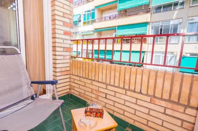 a balcony with a table and a chair and a window at HomeHolidaysRentals Keyla in Pineda de Mar