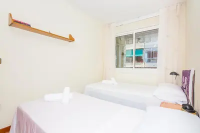two beds in a room with a window at HomeHolidaysRentals Keyla in Pineda de Mar