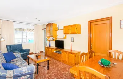 a living room with a couch a table and a tv at HomeHolidaysRentals Keyla in Pineda de Mar
