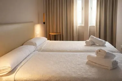 a bedroom with two beds with towels on them at Aparthotel Montcada in Montcada i Reixac