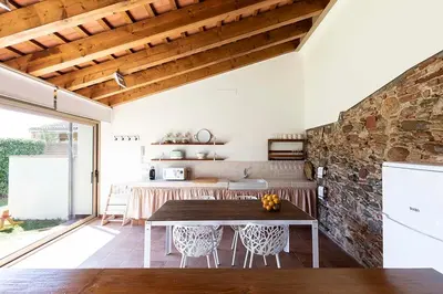 a kitchen with a table and a stone wall at RUSTIC & CHIC b&b in Granollers