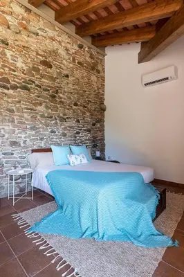 a bed in a room with a brick wall at RUSTIC & CHIC b&b in Granollers