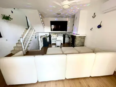 a living room with a white couch and stairs at casa en Masnou junto a playa y tren in Masnou