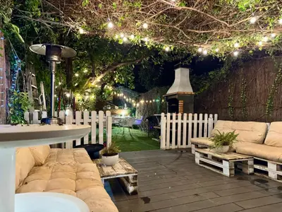 a patio with couches and a table and lights at casa en Masnou junto a playa y tren in Masnou