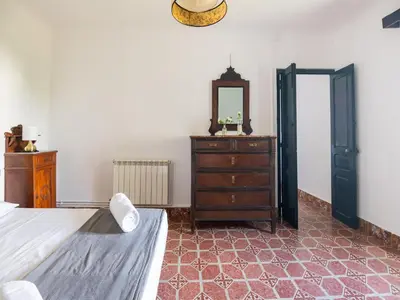 a bedroom with a bed and a dresser and a mirror at Mansion in St Martí with Vineyards & Garden in San Martín Sarroca