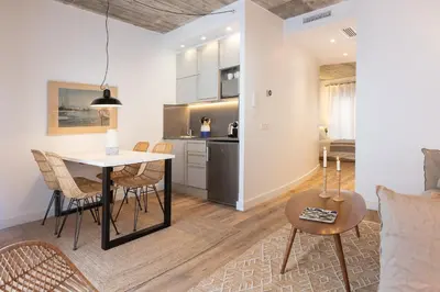 a kitchen and living room with a table and chairs at En Casa de Calders 5 in Barcelona