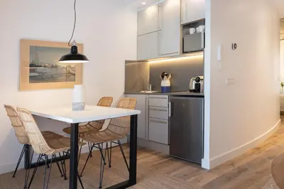 a kitchen with a table and chairs and a refrigerator at En Casa de Calders 5 in Barcelona