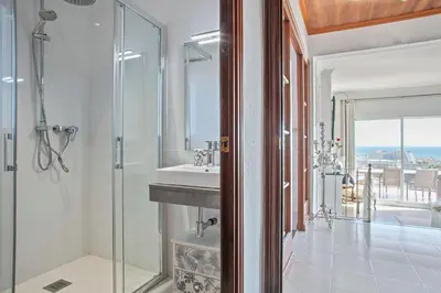 a bathroom with a sink and a glass shower at HOUSE WITH AMAZING VIEWS , OVERLOOKING THE FESTIVAL TOWN OF SITGES in Sitges