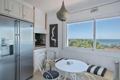 a small kitchen with a table and a window at HOUSE WITH AMAZING VIEWS , OVERLOOKING THE FESTIVAL TOWN OF SITGES in Sitges