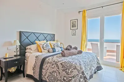 a bedroom with a bed with a view of the ocean at HOUSE WITH AMAZING VIEWS , OVERLOOKING THE FESTIVAL TOWN OF SITGES in Sitges