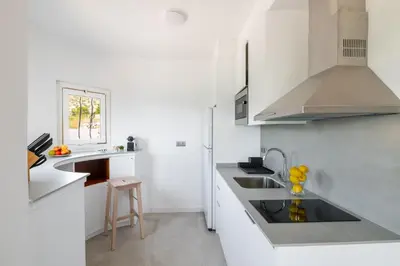 a white kitchen with a sink and a counter at Sitges Blue - completamente reformado en 2025 in Sitges