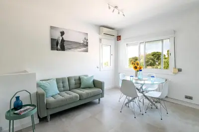 a living room with a couch and a table at Sitges Blue - completamente reformado en 2025 in Sitges
