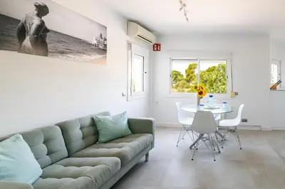 a living room with a couch and a table at Sitges Blue - completamente reformado en 2025 in Sitges