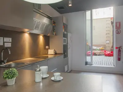 a kitchen with a counter and a sink and a window at No Limit Barcelona Central in Barcelona