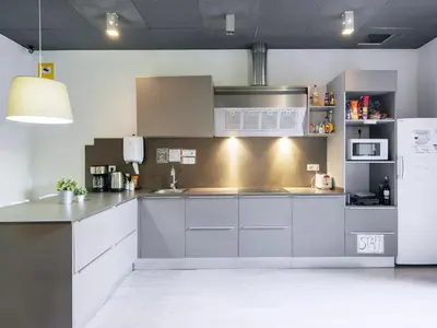 a kitchen with white cabinets and a stainless steel refrigerator at No Limit Barcelona Central in Barcelona