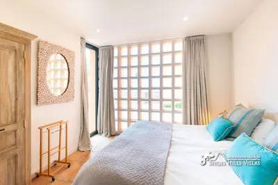 a bedroom with a large bed with blue and white pillows at VILLA DUMAS with amazing sea views, AC and private pool in Sitges