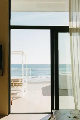 a view of the ocean from a room with a sliding glass door at Playa Grande by Tropical in Gavà