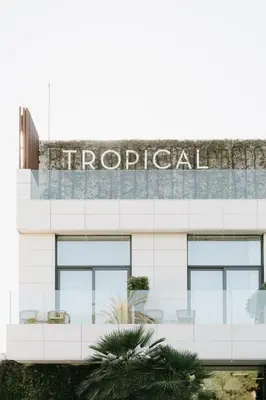 a white building with a hospital sign on it at Playa Grande by Tropical in Gavà