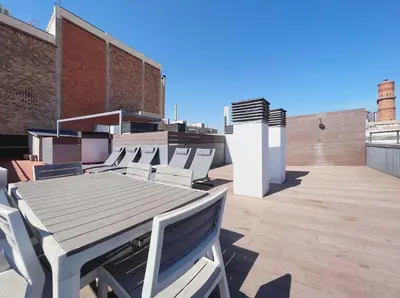 a wooden table and chairs on the roof of a building at Stay U-nique Apartments Pellaires in Barcelona