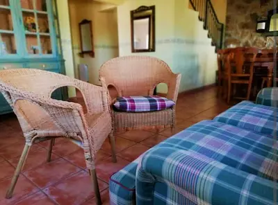 a living room with wicker chairs and a table at MAS DEL VENT- Barbacoa, jardín, piscina privada y vistas a mar in Cunit