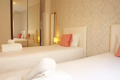 two beds in a hotel room with a mirror at Bcn-rentals apartments in the Old town in Barcelona