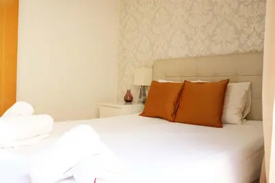 a bedroom with a white bed with orange pillows at Bcn-rentals apartments in the Old town in Barcelona