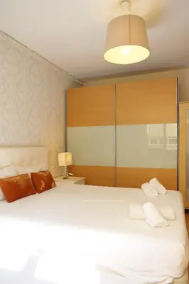 a bedroom with a large white bed with two pillows at Bcn-rentals apartments in the Old town in Barcelona