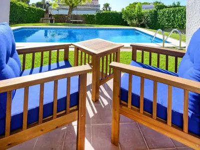two benches sitting next to a swimming pool at Holiday Home Envalira by Interhome in Cunit