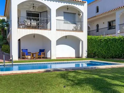 a villa with a swimming pool in front of a house at Holiday Home Envalira by Interhome in Cunit