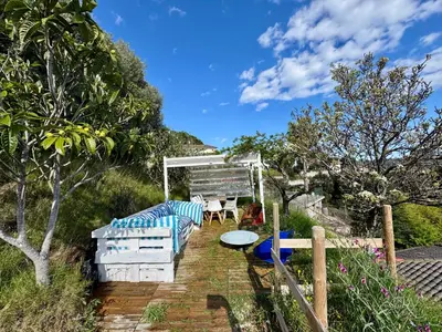 a patio with a table and chairs and trees at CASA PARAÍSO PISCINA TRANQUILIDAD in Sant Cebrià de Vallalta