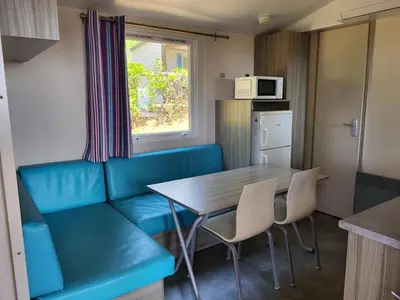 a kitchen with a blue couch and a table and chairs at El Carlitos in Arenys de Mar