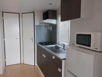a small kitchen with a sink and a microwave at El Carlitos in Arenys de Mar