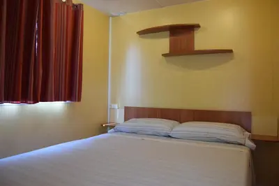 a bedroom with a white bed with a red curtain at El Carlitos in Arenys de Mar