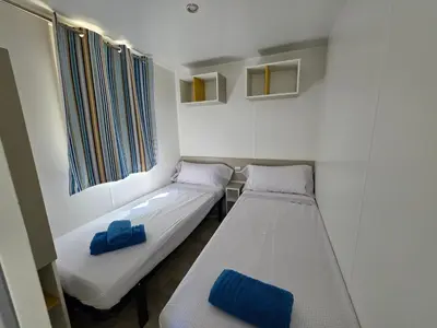 a small room with two beds and a window at El Carlitos in Arenys de Mar