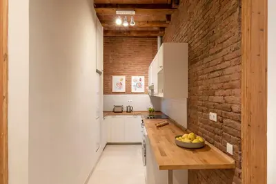 a kitchen with a counter and a brick wall at Aspasios Gracia Apartments in Barcelona