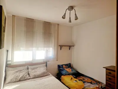 a small bedroom with a bed and a window at APARTAMENTO EN SEGUNDA LINEA DE MAR, WIFI & A.C in Cubelles