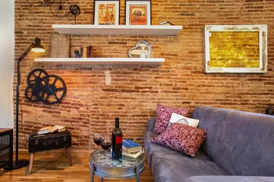a living room with a couch and a brick wall at Stay U-nique Apartments Ramón y Cajal in Barcelona