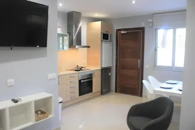 a kitchen with a television and a table and a chair at Alguera Hola Apartments in Barcelona