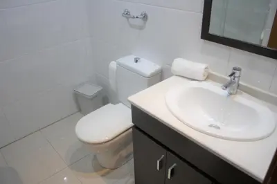 a white bathroom with a toilet and a sink at Alguera Hola Apartments in Barcelona