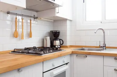 a white kitchen with a stove and a sink at Casa Cosi - Sant Gervasi 1 in Barcelona