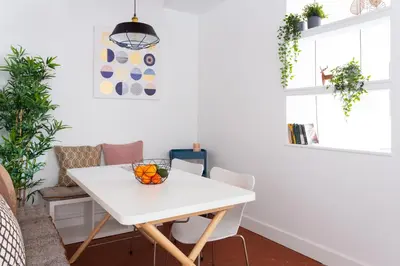 a white dining room table with a bowl of fruit on it at Casa Cosi - Sant Gervasi 1 in Barcelona